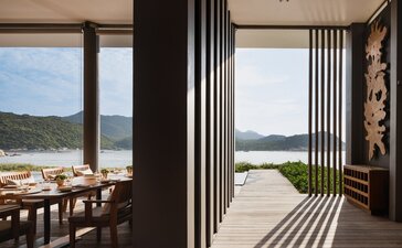 Amanoi beach club restaurant with striped awning overlooking coastal Vietnamese waters.