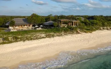 Four-bedroom beachfront villa at Amanyara with sandy beach and turquoise waters.