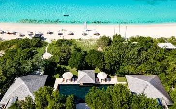 Aerial view of a six-bedroom villa at Amanyara surrounded by tropical vegetation and white-sand beach in Turks and Caicos.
