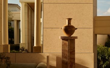 Amanzoe resort interior with stone sculpture and warm architectural lighting.