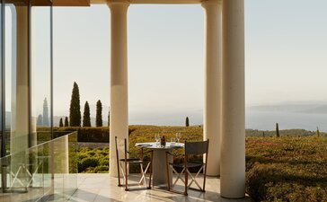 Main restaurant at Amanzoe overlooking the Peloponnese coastline at dusk.