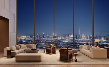 Spacious living room at Aman Residences Dubai with floor-to-ceiling windows framing the city skyline, neutral furnishings, and warm accent lighting.