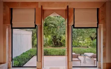 Garden Haveli Suite at Amanbagh with open archways framing views of verdant grounds and courtyard seating.