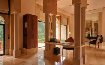 Garden Haveli Suite interior at Amanbagh, featuring warm stone walls, arched doorways and traditional architectural details.