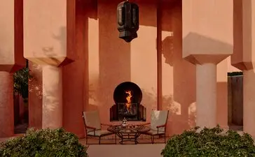 Villa 37 at Amanjena, Morocco, featuring a terracotta courtyard with central water feature and symmetrical columns.