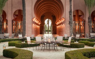 Amanjena's lobby courtyard with symmetrical arches, central fountain, and manicured gardens in Morocco.