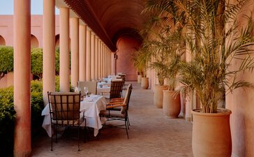 Terracotta colonnade with seating area at Amanjena, Morocco.