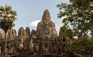 Bayon Temple's stone towers rise amongst tropical vegetation at Amansara's Angkor Temple Tour.