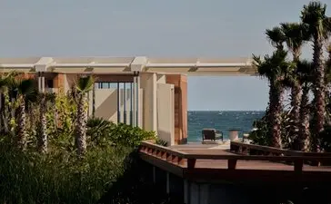 Beachfront casita at Amanvari with ocean views beyond palm trees and coastal vegetation.