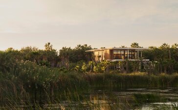 Elevated casita at Amanvari surrounded by lush vegetation and waterfront views in Mexico.