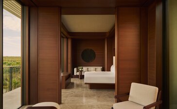 Elevated casita principal bedroom at Amanvari, Mexico, with warm wood panelling and view to ensuite beyond.