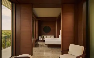 Elevated casita principal bedroom at Amanvari, Mexico, with warm wood panelling and view to ensuite beyond.