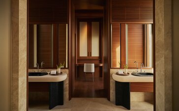 Bathroom at Amanvari with dual vanities, warm wood tones, and minimal styling.