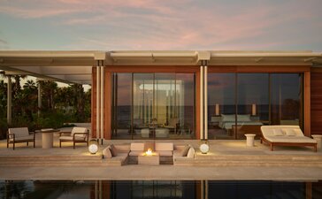 Estuary Casita at Amanvari with floor-to-ceiling windows overlooking the Mexican landscape at dusk.
