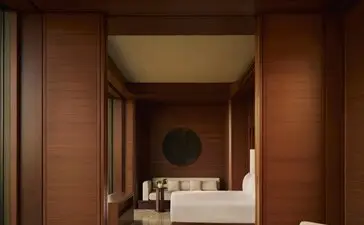 Principal bedroom at Amanvari with warm terracotta walls, contemporary furnishings, and connected ensuite bathroom.