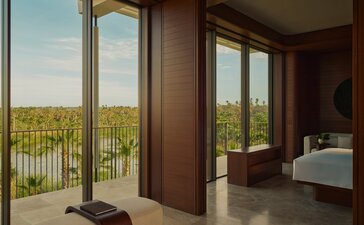 Living area at Amanvari opens to a terrace overlooking Mexico's countryside, with wooden doors and warm interiors.