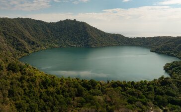 Satonda Lake surrounded by dense forest at Amanwana, Indonesia.