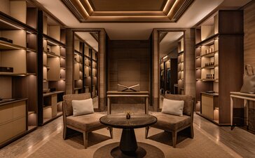 Aman Nai Lert Bangkok room with warm wood cabinetry, soft lighting, and circular seating arrangement.