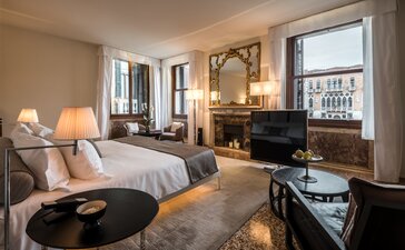 Grand Canal suite at Aman Venice with bed, seating area, and views over Venice's waterways.
