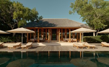 Amanyara villa with thatched roof overlooking turquoise pool, Turks and Caicos.