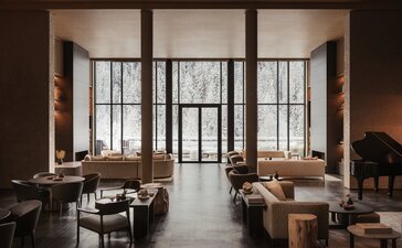 Entrance hall at Aman Rosa Alpina resort with floor-to-ceiling windows and contemporary furnishings.
