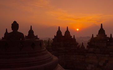 Borobudur temple silhouetted against golden sunrise at Amanjiwo, Indonesia.