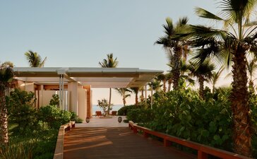 Beachfront casita at Amanvari with terracotta walls, palm trees, and sunset views over the Mexican coast.