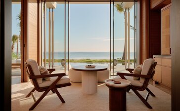 Beachfront casita living area at Amanvari with two chairs facing expansive ocean views through floor-to-ceiling windows.