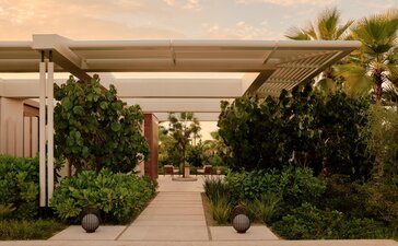 Amanvari estuary casita arrival with pergola-shaded pathway lined by tropical plants.