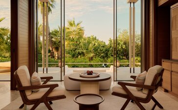 Sala de estar de la Casita Estuary en Amanvari, con vistas al estuario a través de grandes ventanales.