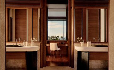 Casita bathroom at Amanvari with dual vanities, warm wood cabinetry and views towards the bedroom beyond.