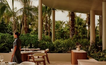 Covered terrace at Amanvari with dining furniture and views towards lush gardens in Mexico.