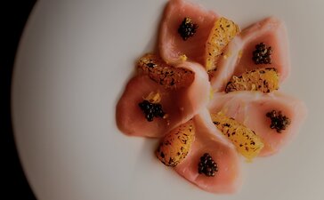 Plated dessert with red fruit coulis and gold leaf at Amanvari, Mexico.