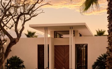 Spa entrance at Amanvari with sculptural pavilion at dusk, framed by desert palms.