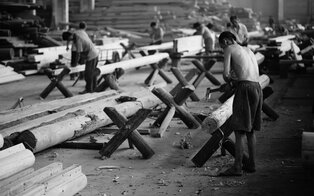 Wooden benches and tables stacked in a courtyard at Amanyangyun, black and white photograph.