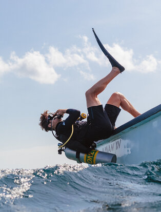 Diver entering the water during a dive centre experience at Amanwana.