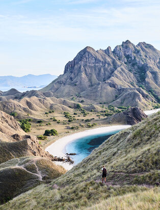 Amandira's turquoise lake nestled between rugged mountain peaks and arid valleys in Indonesia.