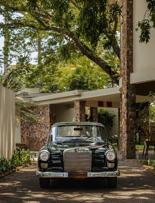 Vintage car parked beneath a shaded pergola at Amansara, Cambodia.
