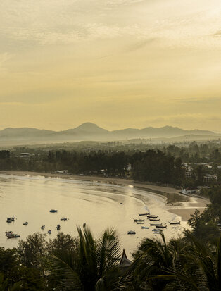 Andaman Sea at dusk, viewed from Amanpuri, with forested coastline and distant hills.