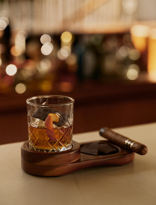 Rum cocktail served over ice at Amanera, Dominican Republic, with warm lighting in the background.