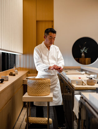 アマン東京のシェフ、武蔵裕之が厨房で調理の準備をしている写真