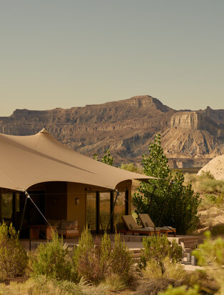 Beige canvas tent exterior at Amangiri resort in Utah, with desert mountains beyond.