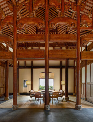 Dining room at Amanyangyun villa with four bedrooms, featuring traditional wooden architecture and open-plan layout.