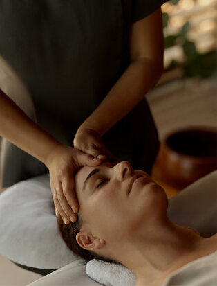 Therapist performing a facial massage treatment at Amanyara spa.