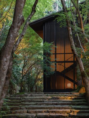 Modern wooden pavilion nestled among towering trees at Aman Kyoto, Japan.