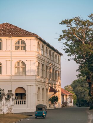 Amangalla's distinctive terracotta exterior with arched windows at dusk, Sri Lanka.