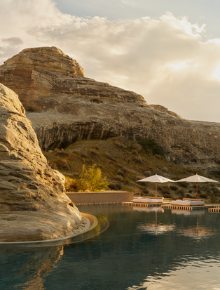 Piscine principale d'Amangiri, station balnéaire, avec bassins d'eau turquoise entourés de formations rocheuses désertiques.