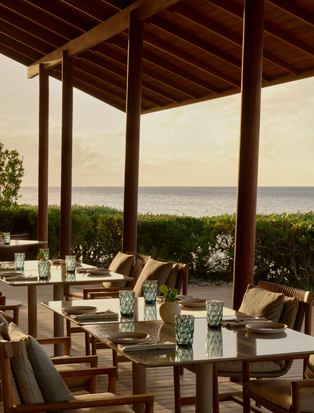 Beach Club restaurant at Amanyara with open-air dining pavilion overlooking turquoise waters.