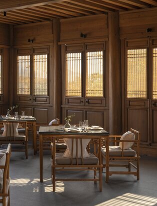 Dining venue at Amandayan with wooden latticed doors and a round table set for service.