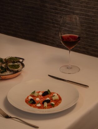 Red wine and seafood pasta dish at Aman Nai Lert Bangkok dining venue.